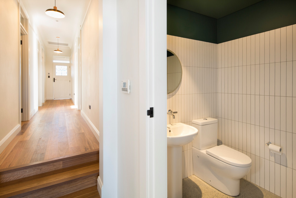 Kleine Klassische Gästetoilette mit Toilette mit Aufsatzspülkasten, weißen Fliesen, Keramikfliesen, weißer Wandfarbe, Betonboden, Sockelwaschbecken und grauem Boden in Sydney