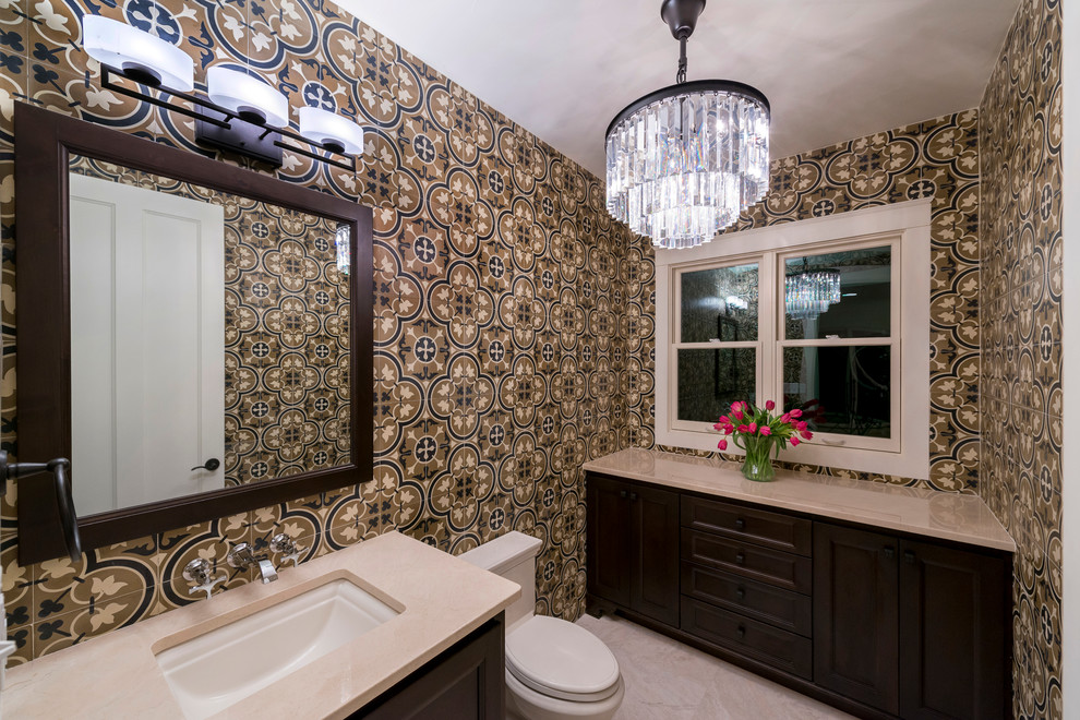 Design ideas for a large traditional cloakroom in Austin with recessed-panel cabinets, dark wood cabinets, a one-piece toilet, mosaic tiles, multi-coloured walls, limestone flooring, a submerged sink, engineered stone worktops, beige floors and beige worktops.