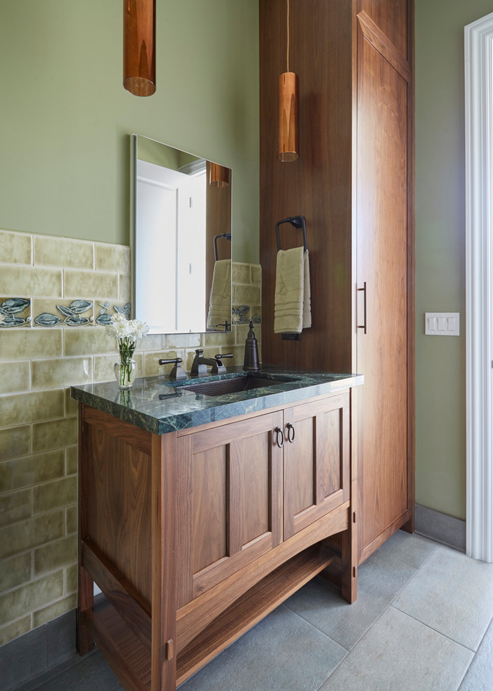 Aménagement d'un WC et toilettes craftsman en bois brun avec un placard avec porte à panneau encastré, un carrelage vert, des carreaux de céramique, un mur vert, un sol en carrelage de porcelaine, un lavabo encastré, un plan de toilette en marbre, un sol vert et un plan de toilette vert.