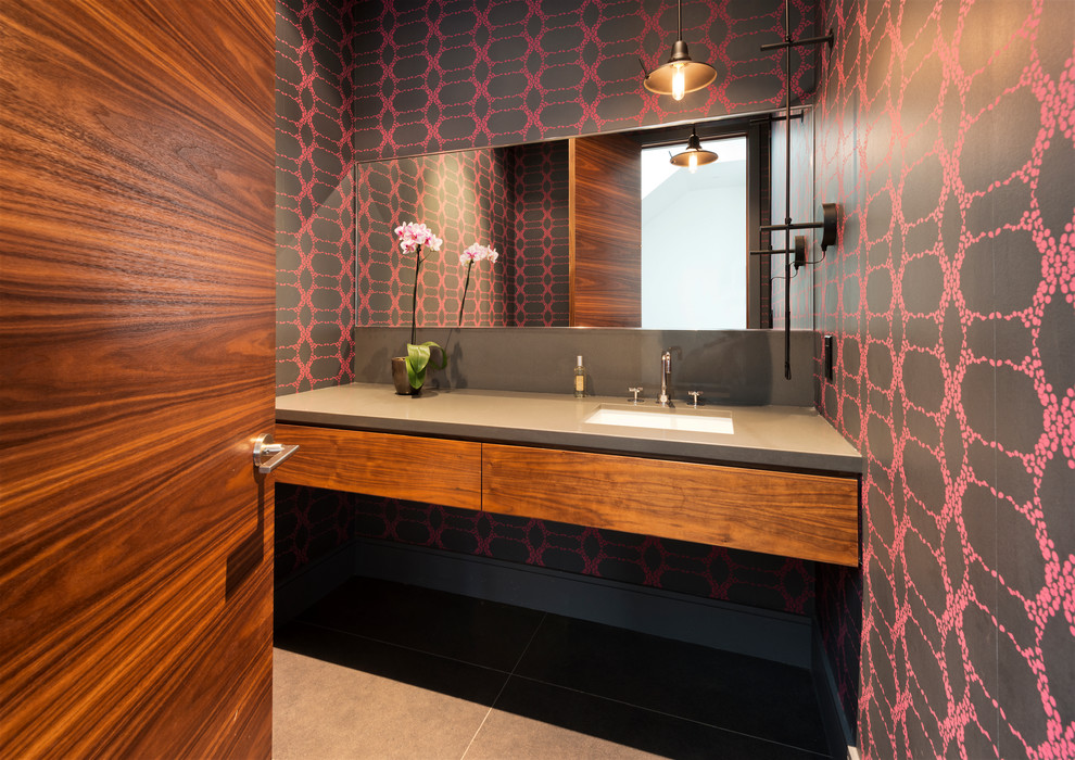 Diseño de aseo contemporáneo con lavabo bajoencimera, armarios con paneles lisos, puertas de armario de madera oscura y paredes multicolor