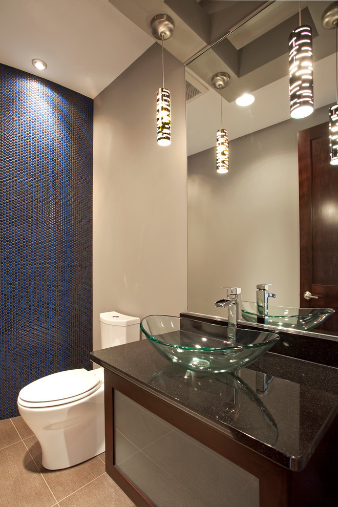 На фото: туалет в современном стиле с настольной раковиной, темными деревянными фасадами, столешницей из гранита, синей плиткой и плиткой мозаикой