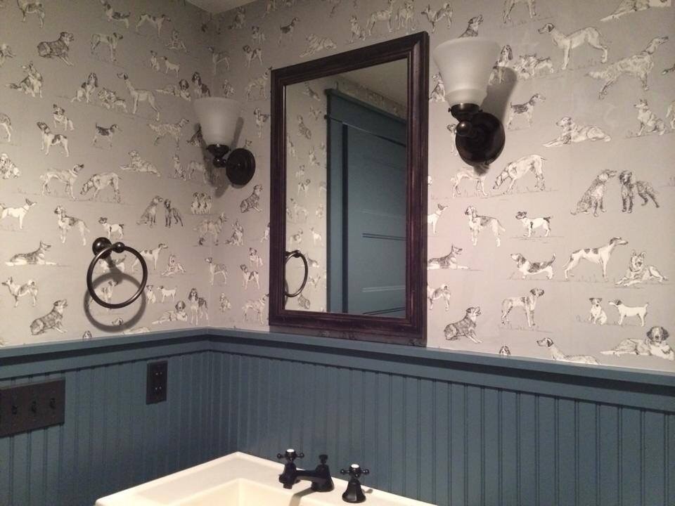 Inredning av ett lantligt mellanstort toalett, med en toalettstol med separat cisternkåpa, flerfärgade väggar, mörkt trägolv, ett piedestal handfat och brunt golv
