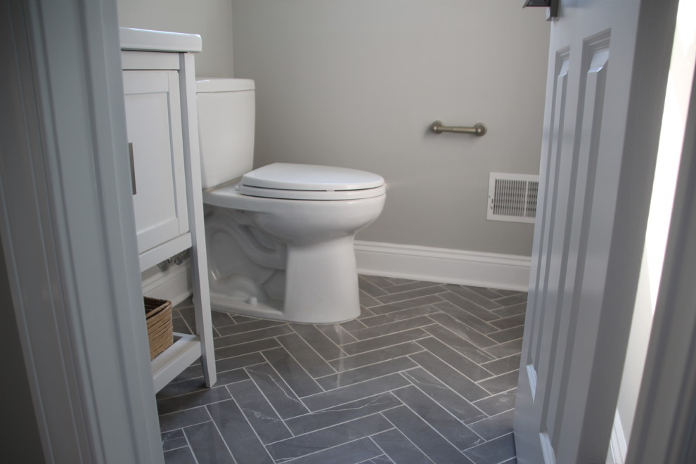 Design ideas for a small traditional cloakroom in New York with shaker cabinets, white cabinets, a two-piece toilet, grey walls, marble flooring, a submerged sink, engineered stone worktops and grey floors.