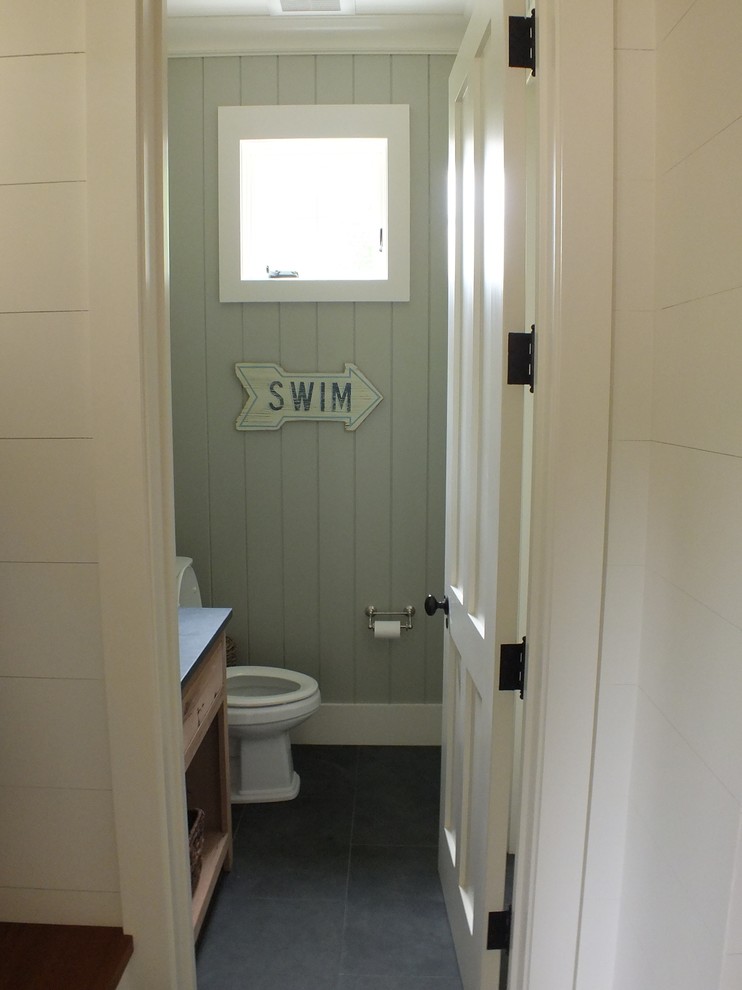 Cette image montre un petit WC et toilettes traditionnel en bois brun avec un lavabo encastré, un placard à porte plane, un plan de toilette en calcaire, WC séparés, un mur gris et un sol en ardoise.