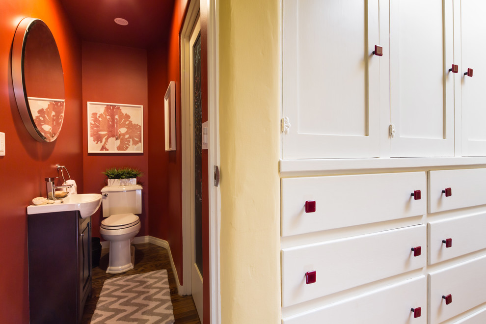 Mittelgroße Shabby-Style Gästetoilette mit Wandtoilette mit Spülkasten, roter Wandfarbe, dunklem Holzboden und integriertem Waschbecken in Los Angeles
