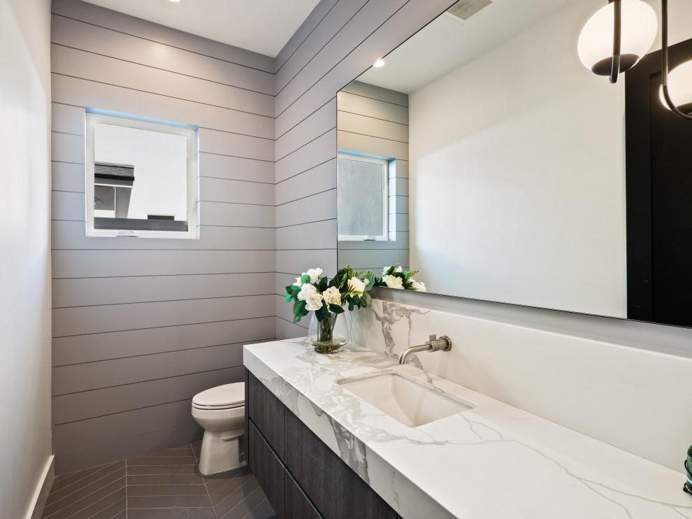 Aménagement d'un WC et toilettes campagne en bois foncé de taille moyenne avec un mur gris, un lavabo encastré, un plan de toilette en marbre, un plan de toilette multicolore, meuble-lavabo suspendu et du lambris.