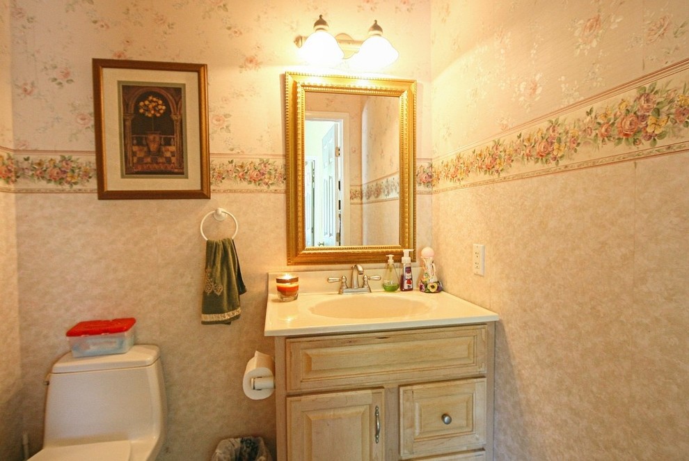 Foto di un bagno di servizio tradizionale di medie dimensioni con ante in legno chiaro, pareti beige e pavimento in legno massello medio