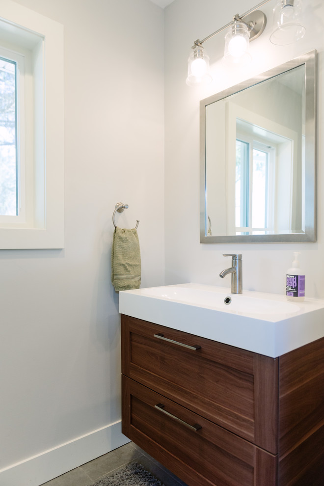 Exemple d'un WC et toilettes moderne en bois brun de taille moyenne avec un placard à porte shaker, un sol en carrelage de porcelaine, une grande vasque, un plan de toilette en quartz modifié et un sol gris.