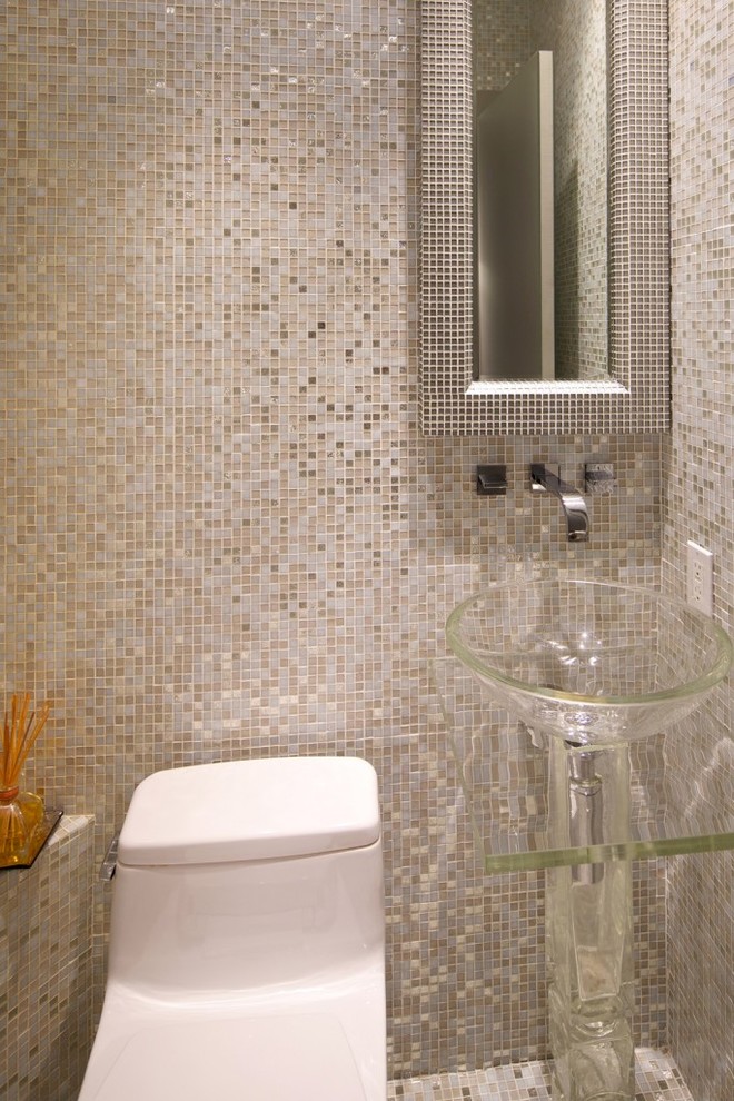 This is an example of a small contemporary cloakroom in New York with a one-piece toilet, beige tiles, white tiles, grey tiles, multi-coloured tiles, mosaic tiles, beige walls, mosaic tile flooring and a vessel sink.