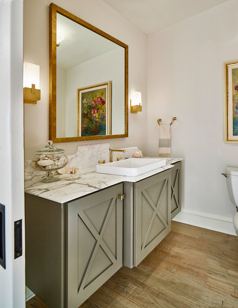 Источник вдохновения для домашнего уюта: туалет в стиле неоклассика (современная классика) с серыми фасадами, серыми стенами, паркетным полом среднего тона, накладной раковиной, коричневым полом и белой столешницей