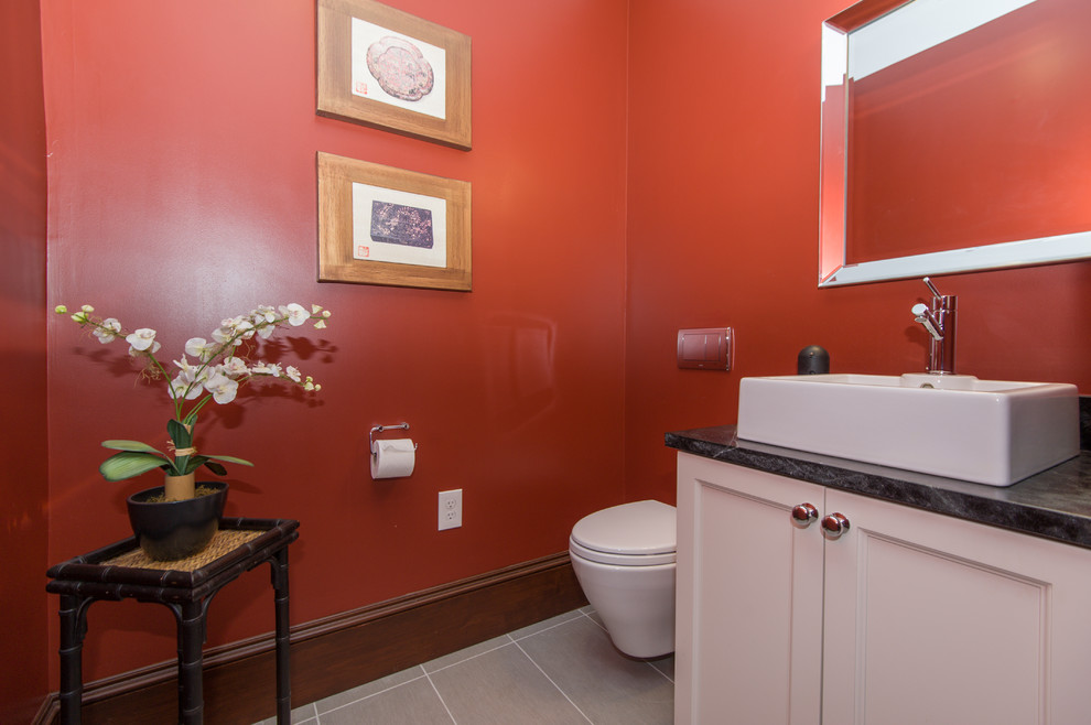 Example of a small classic gray tile and porcelain tile porcelain tile powder room design in Boston with recessed-panel cabinets, white cabinets, a wall-mount toilet, red walls, a vessel sink and soapstone countertops