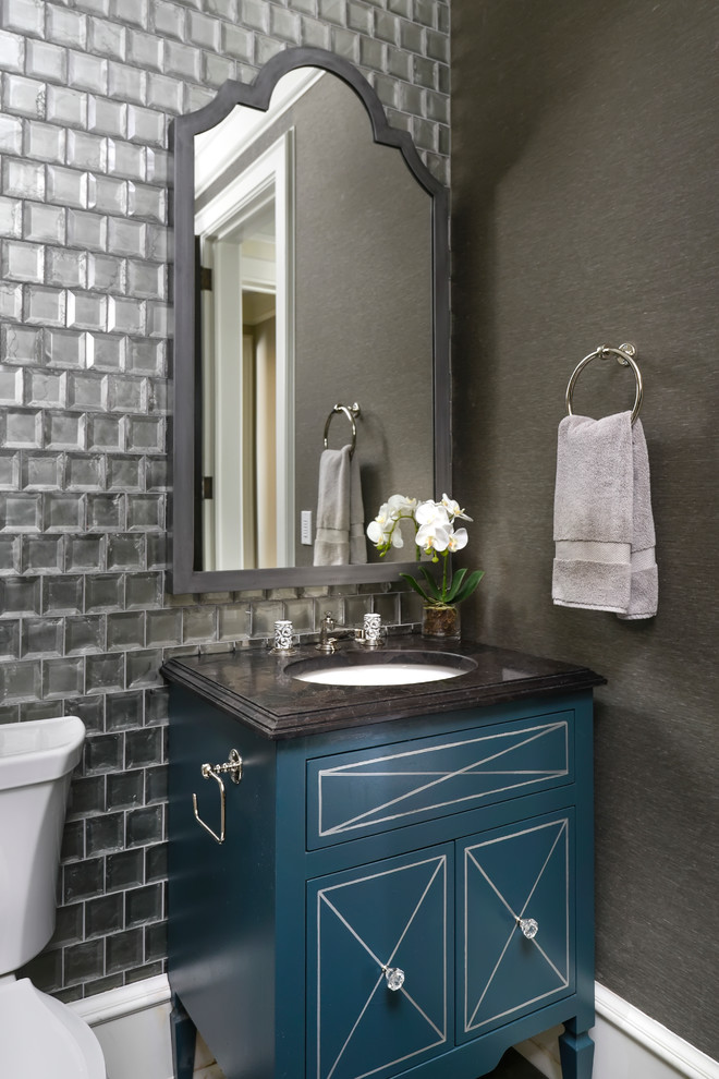 На фото: туалет в стиле неоклассика (современная классика) с фасадами островного типа, синими фасадами, раздельным унитазом, серой плиткой, стеклянной плиткой, серыми стенами и врезной раковиной