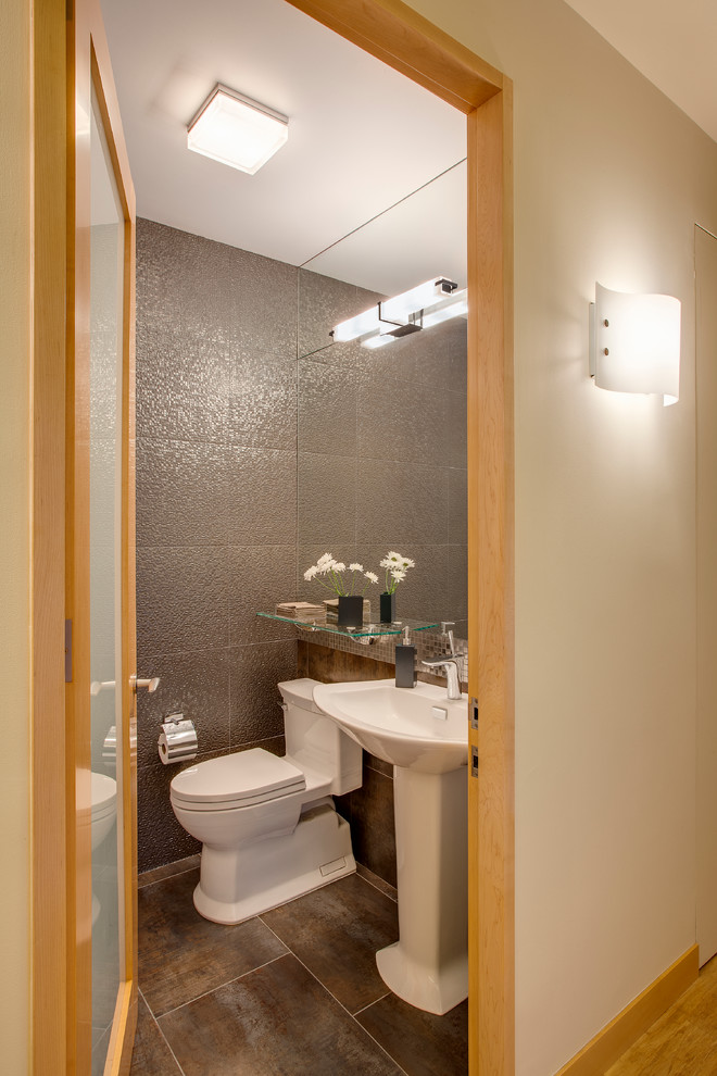 Cette photo montre un WC et toilettes tendance de taille moyenne avec WC séparés, un carrelage gris, des carreaux de céramique, un mur gris, un sol en carrelage de céramique, un lavabo de ferme, un plan de toilette en surface solide et un sol marron.