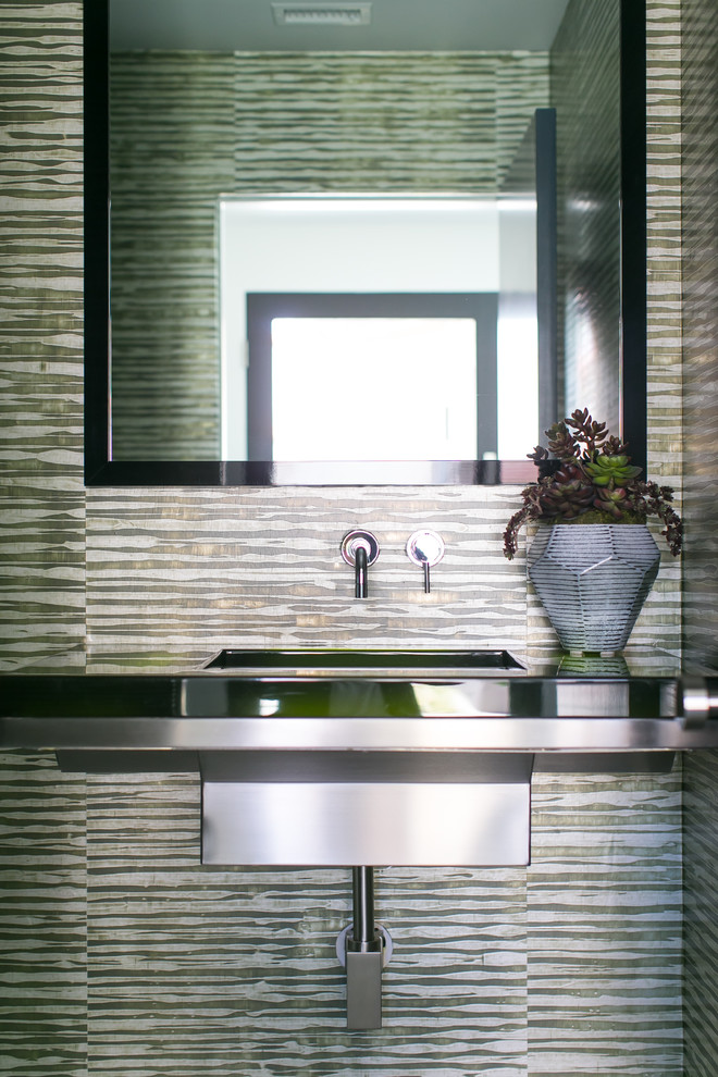 Immagine di un bagno di servizio design di medie dimensioni con WC monopezzo, pareti verdi, pavimento in gres porcellanato e lavabo integrato