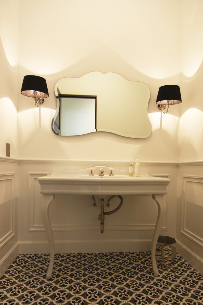 This is an example of a medium sized classic cloakroom in Orange County with a two-piece toilet, a console sink, white walls and marble flooring.