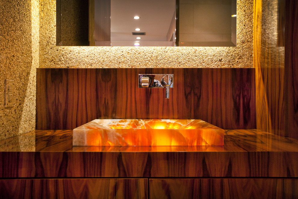 Immagine di un bagno di servizio contemporaneo di medie dimensioni con ante lisce, ante in legno bruno, lavabo a bacinella, top in legno e pareti beige