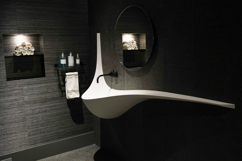 Idée de décoration pour un WC et toilettes design de taille moyenne avec un mur gris, un sol en carrelage de porcelaine et un sol gris.