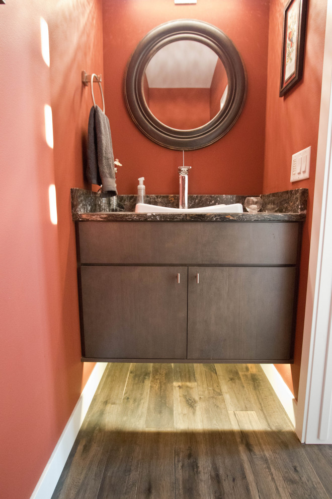 Idée de décoration pour un petit WC et toilettes avec un placard à porte plane, des portes de placard marrons, un mur rouge, parquet foncé, un lavabo posé, un sol marron, un plan de toilette gris et meuble-lavabo suspendu.