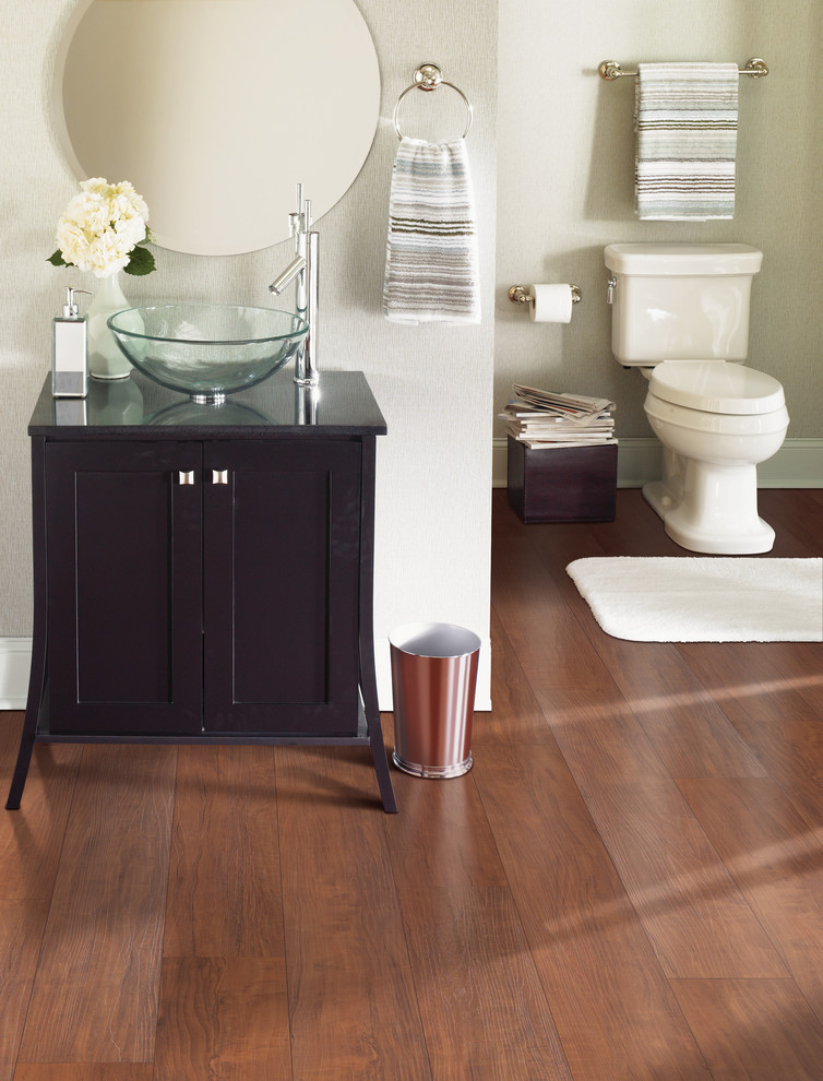 Design ideas for a medium sized traditional cloakroom in Atlanta with freestanding cabinets, dark wood cabinets, a two-piece toilet, beige walls, medium hardwood flooring, a vessel sink, wooden worktops and brown floors.