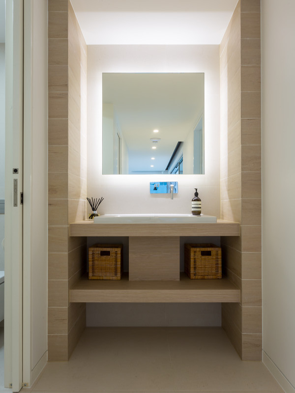 Exempel på ett litet modernt toalett, med ett nedsänkt handfat, öppna hyllor, skåp i ljust trä, laminatbänkskiva, porslinskakel, vita väggar, klinkergolv i porslin och beige kakel