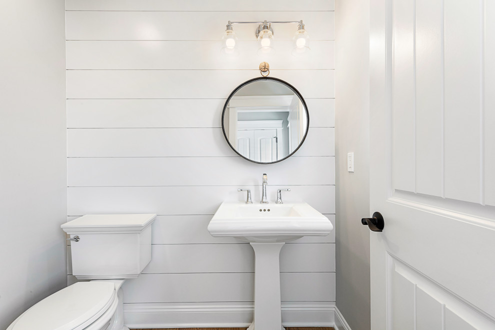 На фото: туалет в морском стиле с унитазом-моноблоком, серыми стенами, светлым паркетным полом, раковиной с пьедесталом и стенами из вагонки