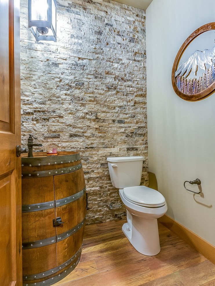 Cette photo montre un WC et toilettes craftsman en bois foncé avec un placard en trompe-l'oeil, WC séparés, un carrelage gris, un carrelage de pierre, un plan de toilette en bois, un plan de toilette marron, un mur gris, un sol en bois brun, un lavabo posé et un sol marron.