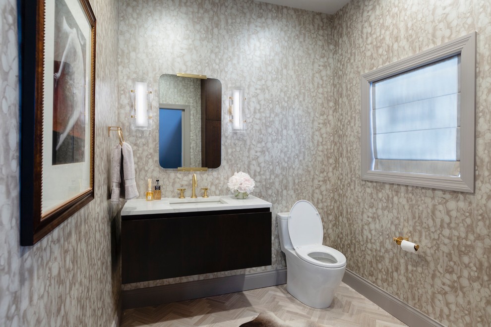 Foto på ett stort funkis vit toalett, med släta luckor, skåp i mörkt trä, en toalettstol med hel cisternkåpa, klinkergolv i porslin, ett undermonterad handfat, marmorbänkskiva och beiget golv