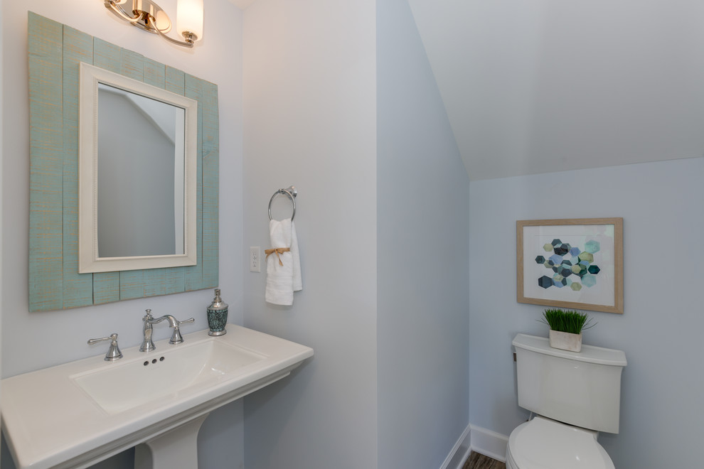 Ispirazione per un bagno di servizio stile marinaro di medie dimensioni con WC monopezzo, pareti blu, parquet chiaro, lavabo a colonna e pavimento marrone