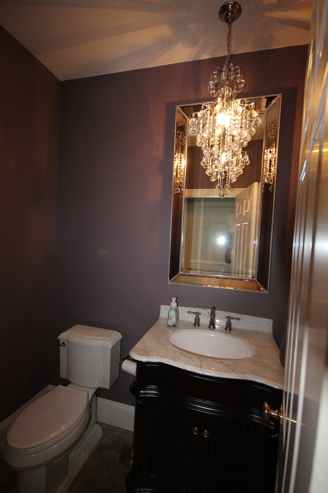 Bild på ett mellanstort vintage toalett, med möbel-liknande, skåp i mörkt trä, en toalettstol med separat cisternkåpa, lila väggar, ett undermonterad handfat och marmorbänkskiva