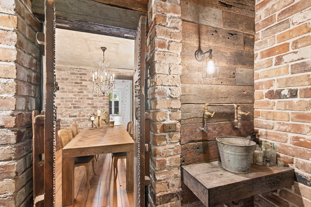 シドニーにあるラスティックスタイルのおしゃれなトイレ・洗面所 (茶色い壁、ベッセル式洗面器、木製洗面台、ブラウンの洗面カウンター) の写真