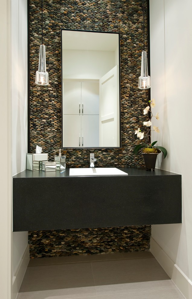 На фото: туалет в современном стиле с накладной раковиной, галечной плиткой, серой плиткой и акцентной стеной с