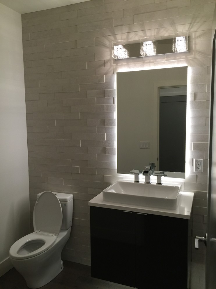 Cette photo montre un petit WC et toilettes moderne en bois foncé avec un placard à porte plane, WC à poser, un carrelage blanc, un carrelage de pierre, un mur blanc, une vasque et un plan de toilette en quartz.