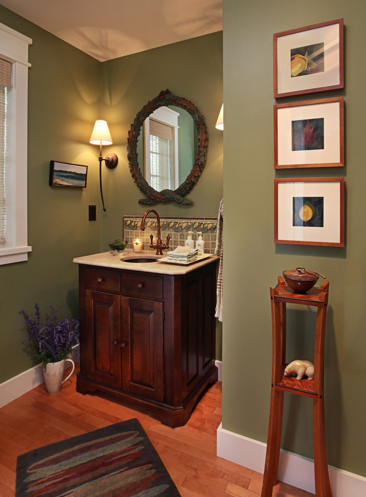Mid-sized elegant medium tone wood floor and brown floor powder room photo in Detroit with furniture-like cabinets, dark wood cabinets, green walls, an undermount sink and granite countertops