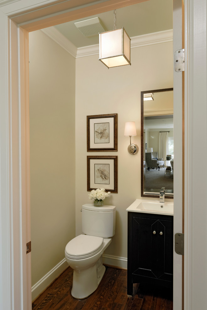 This is an example of a medium sized traditional cloakroom in DC Metro with an integrated sink, freestanding cabinets, dark wood cabinets, marble worktops, a two-piece toilet and beige walls.