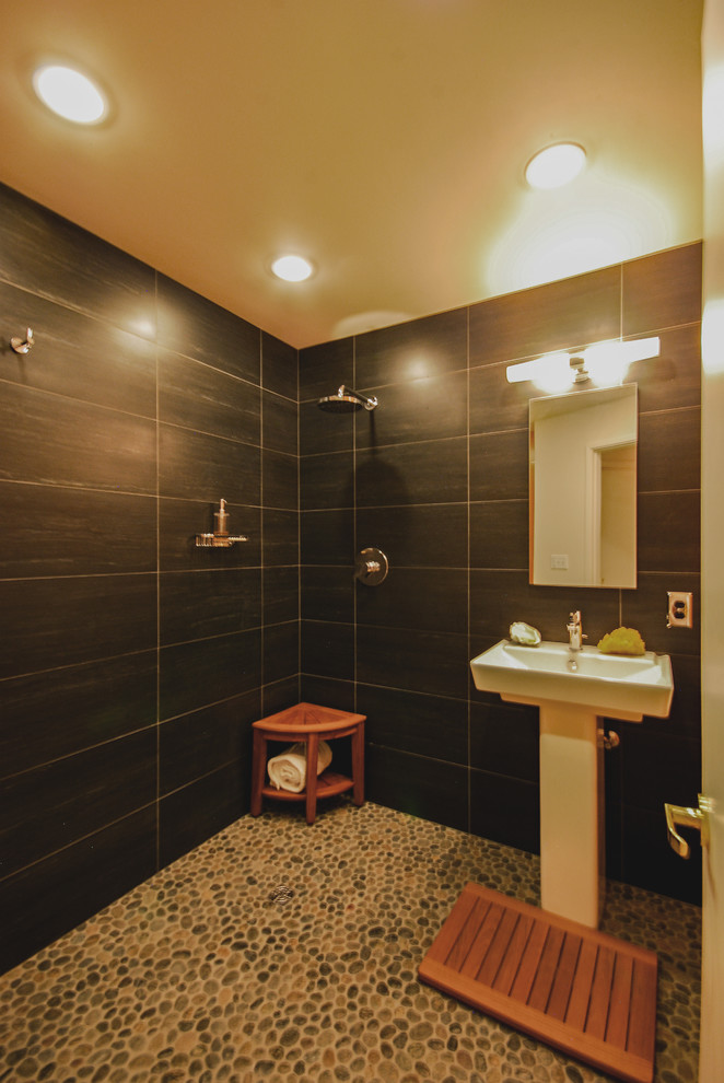 Idee per un piccolo bagno di servizio minimal con piastrelle nere, piastrelle in ceramica, pareti bianche, pavimento con piastrelle di ciottoli, lavabo a colonna, pavimento marrone e WC monopezzo