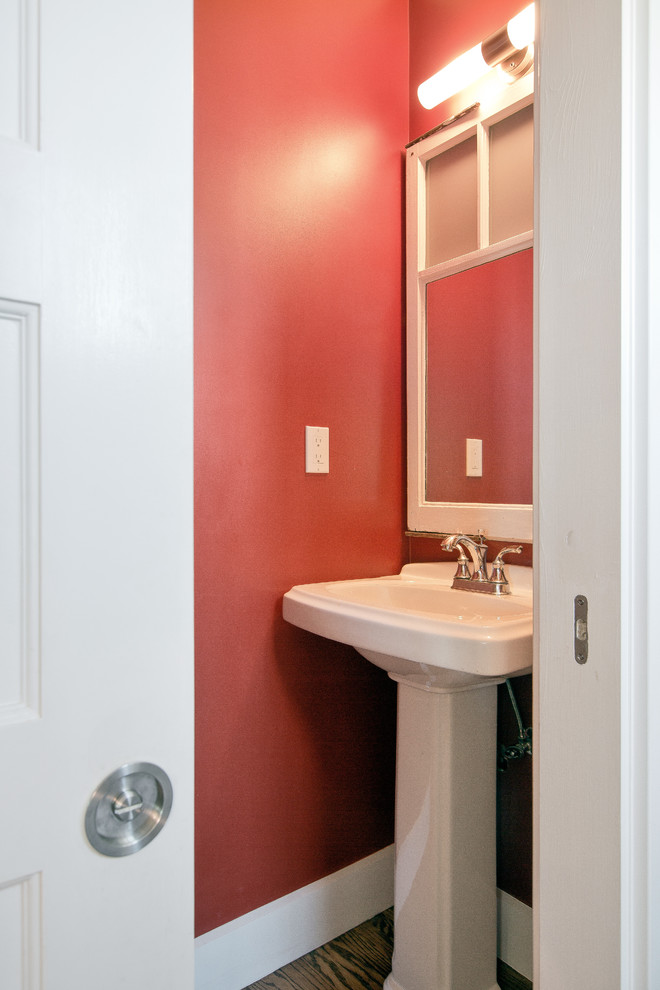 Ispirazione per un piccolo bagno di servizio chic con pareti rosse, pavimento in legno massello medio, lavabo a colonna e pavimento marrone