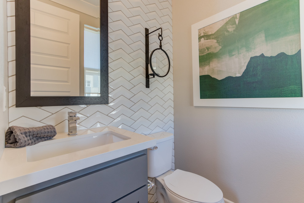 Example of a white tile powder room design in San Francisco with a two-piece toilet and an undermount sink
