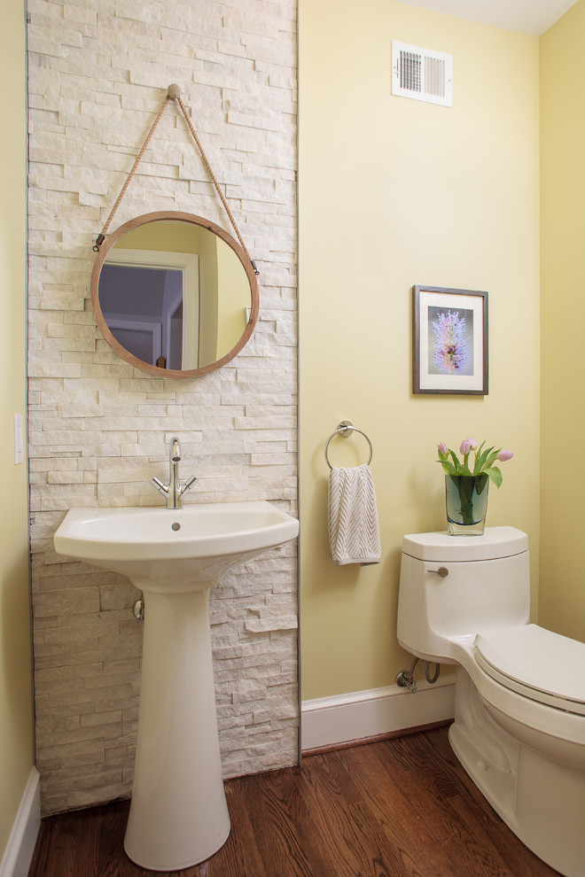 This is an example of a small modern cloakroom in DC Metro with a one-piece toilet, white tiles, stone tiles, yellow walls, medium hardwood flooring and a trough sink.