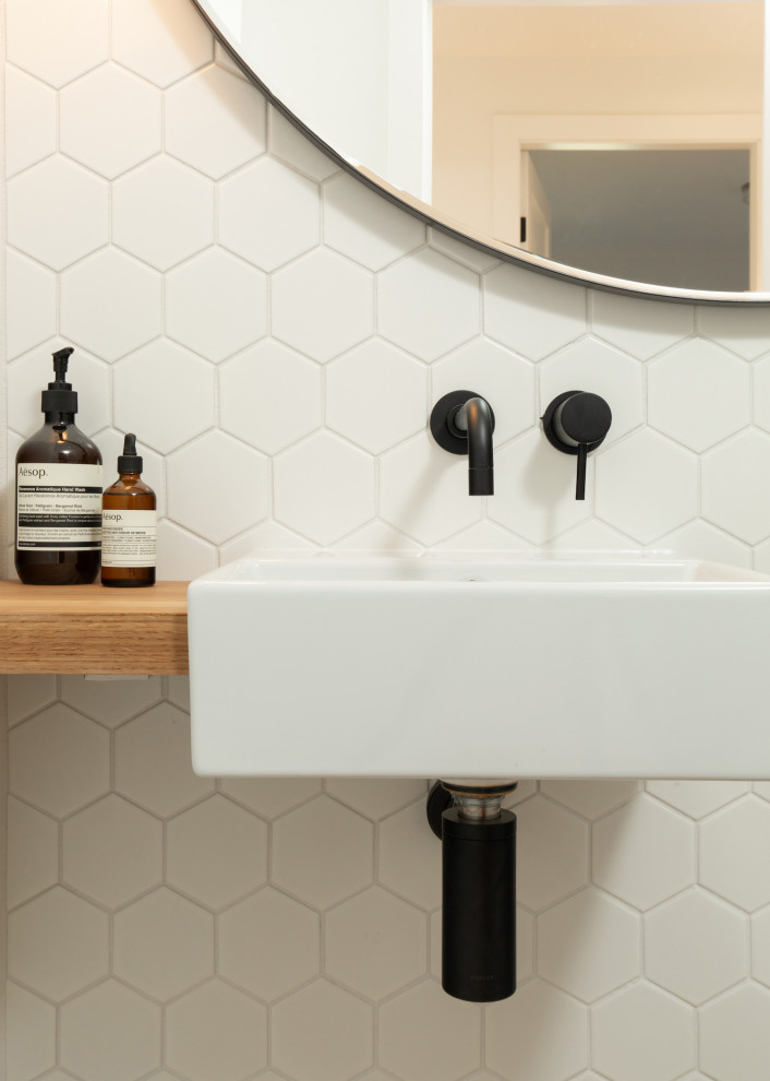 Kleine Moderne Gästetoilette mit weißen Fliesen, Mosaikfliesen, hellem Holzboden, Wandwaschbecken, Waschtisch aus Holz und schwebendem Waschtisch in Vancouver