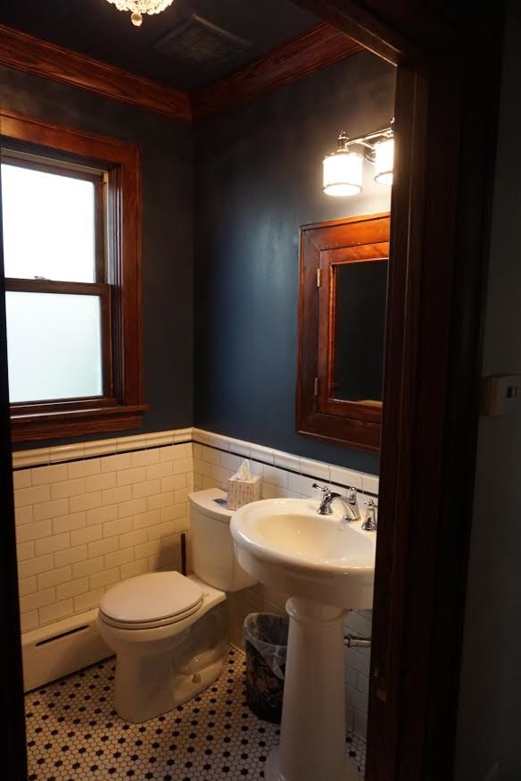 This is an example of a medium sized traditional cloakroom in Chicago with glass-front cabinets, dark wood cabinets, a two-piece toilet, white tiles, metro tiles, blue walls, ceramic flooring, a pedestal sink, solid surface worktops and white floors.