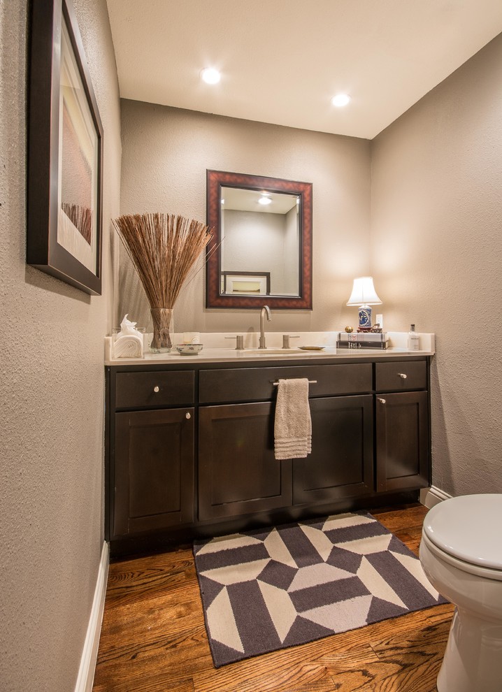Inspiration for a small modern cloakroom in Dallas with a submerged sink, shaker cabinets, dark wood cabinets, a two-piece toilet, beige walls and medium hardwood flooring.