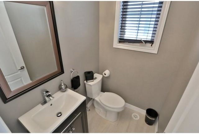 Immagine di un piccolo bagno di servizio minimalista con ante in stile shaker, ante in legno bruno, WC monopezzo, piastrelle beige, piastrelle in ceramica, pareti grigie, pavimento con piastrelle in ceramica, lavabo integrato e top in granito