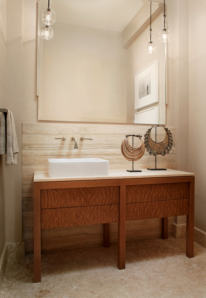 Exemple d'un grand WC et toilettes exotique en bois brun avec un mur beige, un lavabo suspendu et un plan de toilette en marbre.