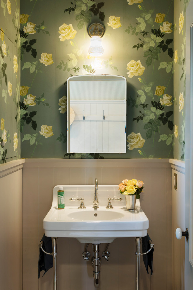 Diseño de aseo tradicional con paredes verdes, lavabo tipo consola, boiserie y papel pintado