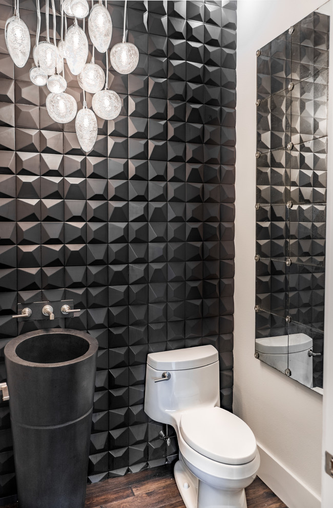 Idee per un piccolo bagno di servizio design con WC monopezzo, piastrelle nere, pavimento in legno massello medio, lavabo a colonna e pavimento marrone