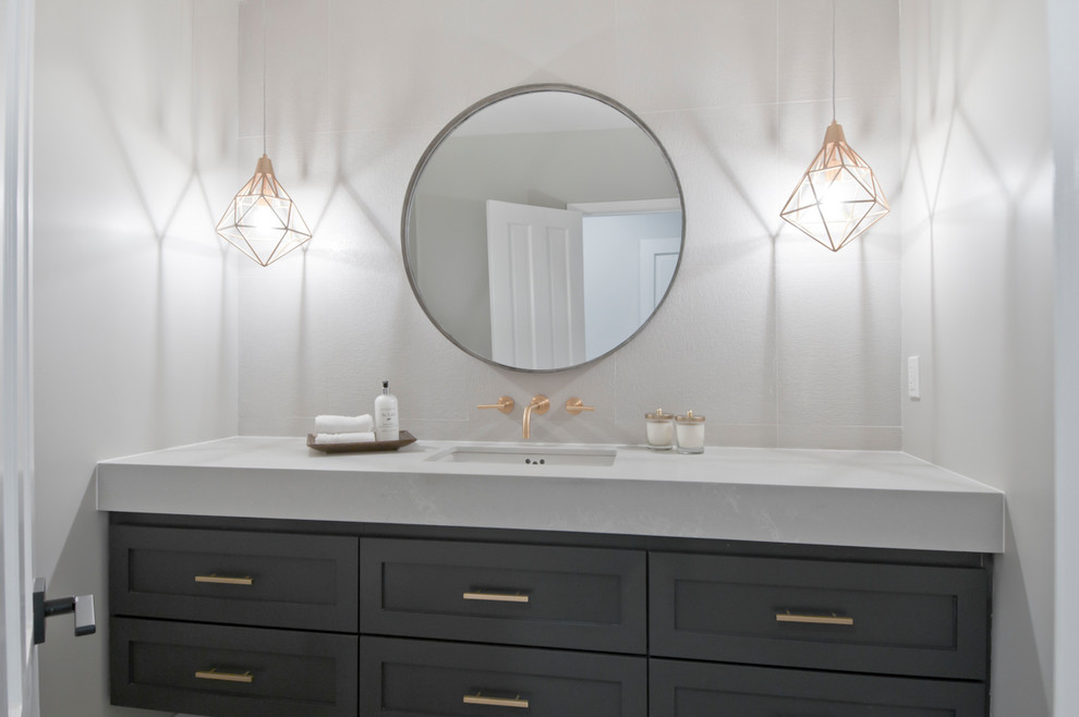 Example of a mid-sized transitional white tile and stone tile marble floor and beige floor powder room design in Los Angeles with shaker cabinets, gray cabinets, a two-piece toilet, gray walls, an undermount sink, quartzite countertops and white countertops