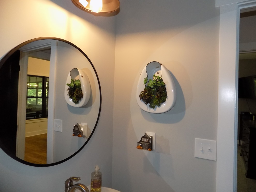 Mittelgroße Rustikale Gästetoilette mit Wandtoilette mit Spülkasten, grauer Wandfarbe, Laminat, Sockelwaschbecken und braunem Boden in Kolumbus