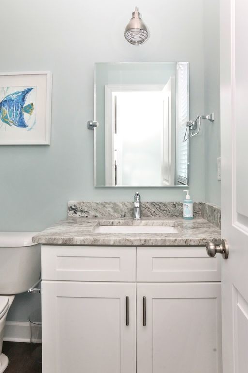 Inspiration for a medium sized nautical cloakroom in Other with shaker cabinets, white cabinets, a two-piece toilet, blue tiles, blue walls, medium hardwood flooring, a submerged sink, engineered stone worktops, brown floors and grey worktops.