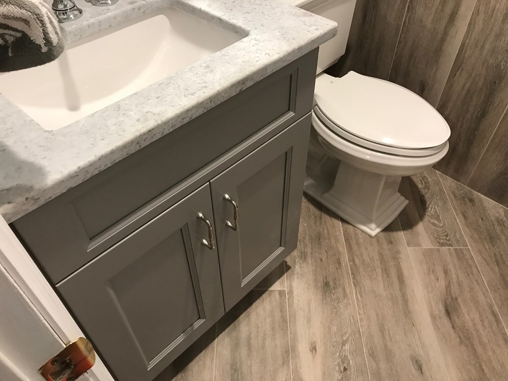 Idéer för ett litet klassiskt grå toalett, med skåp i shakerstil, grå skåp, en toalettstol med separat cisternkåpa, mellanmörkt trägolv, ett undermonterad handfat, granitbänkskiva, grå kakel, stenkakel, grå väggar och brunt golv