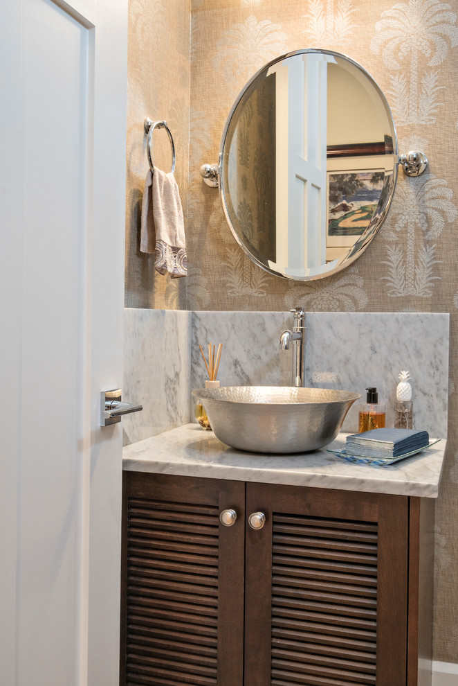 Example of a large transitional brown tile and stone slab powder room design in Miami with louvered cabinets, dark wood cabinets, beige walls, a vessel sink and marble countertops